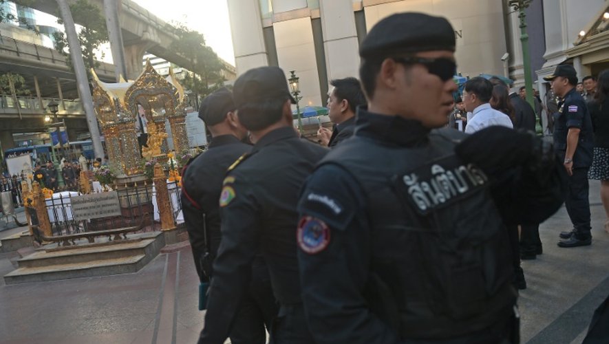 Des policiers assurent la sécurité sur le site de l'attentat de lundi contre un sanctuaire de Bangkok lors d'une cérémonie vendredi 21 août