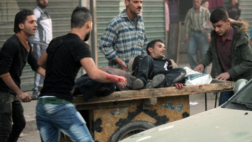 Deux hommes blessés sont transportés à Alep, le 26 octobre 2013