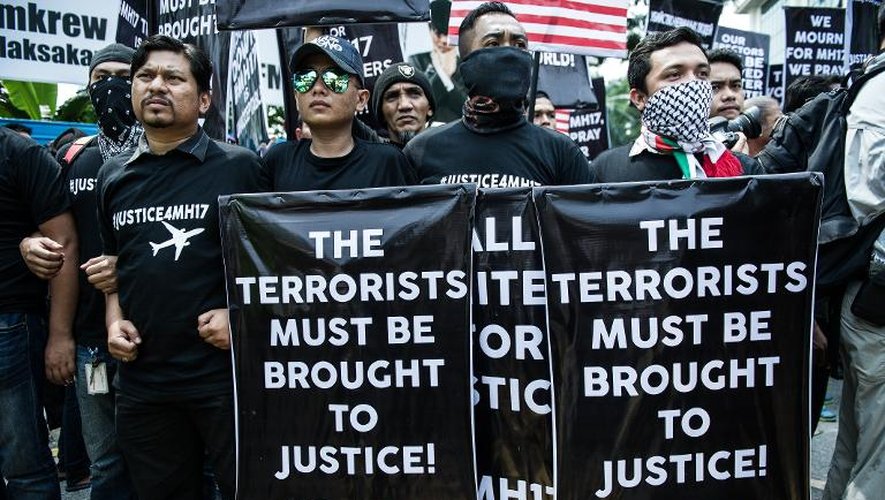 Des Malaisiens déploient des pancartes réclamant que les terroristes du vols MH17 soient remis à la justice lors d'une manifestation devant l'ambassade de Russie, à Kuala Lumpur, le 22 juillet 2014