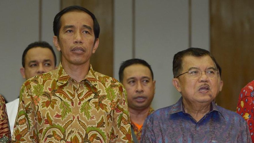 Le nouveau président indonésien Joko Widodo (g) et le vice-président Jusuf Kalla (d), chantent l'hymne national après l'annonce du scrutin, le 22 juillet 2014 à Jakarta