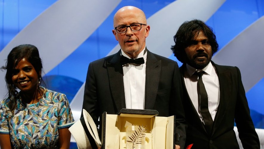 Le réalisateur français Jacques Audiard (c) et les acteurs sri lankais Kalieaswari Srinivasan (g) et Jesuthasan Antonythasan (d) reçoivent la Palme d'Or pour le film "Dheepan", lors du 68ème Festival de Cannes, le 24 mai 2015