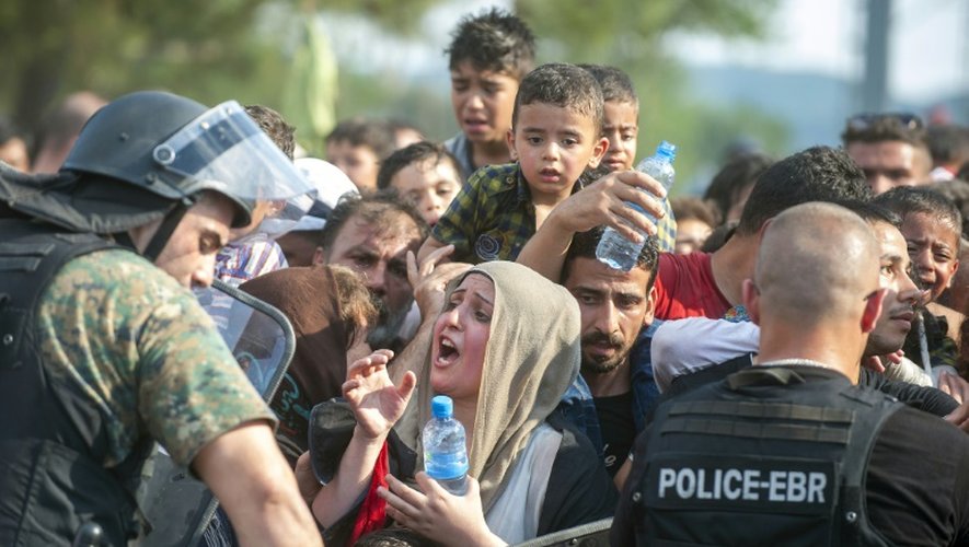 La police bloque un groupe de migrants qui tentent le 21 août 2015 de passer la frontière dans la ville de Gevgelija, en Macédoine pour rejoindre l'Europe occidentale