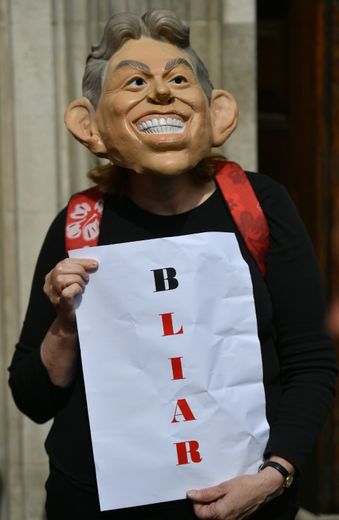Un manifestant porte un masque de Tony Blair et une pancarte jouant avec les mots Blair et Liar (menteur) à Londres le 6 juillet 2016