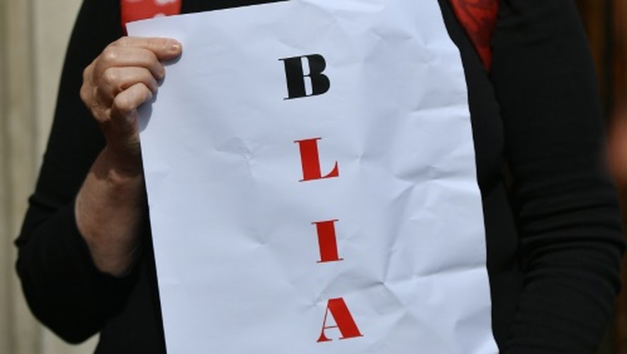 Un manifestant porte un masque de Tony Blair et une pancarte jouant avec les mots Blair et Liar (menteur) à Londres le 6 juillet 2016