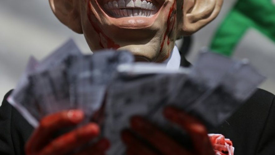 Un manifestant porte un masque de Tony Blair les mains ensanglantées pour protester contre son rôle dans la guerre en Irak, à Londres le 6 juillet 2016