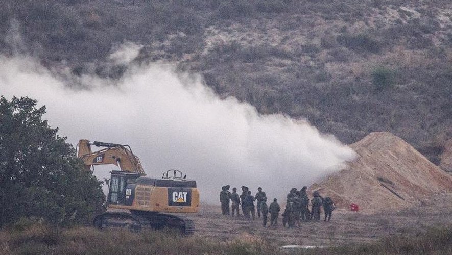 Des soldats israéliens pulvérisent du gaz, le 22 juillet 2014 à la sortie d'un tunnel utilisé par des militants du Hamas pour mener des incursions en Israël