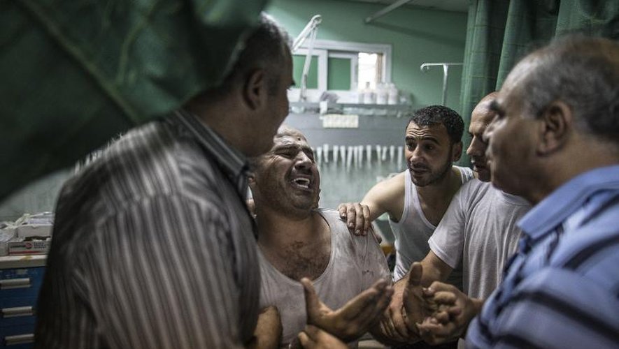 Un Palestinien hurle sa douleur alors que sa fille est gravement blessée après un bombardement israélien à Beit Lahia, dans le nord de Gaza, le 22 juillet 2014