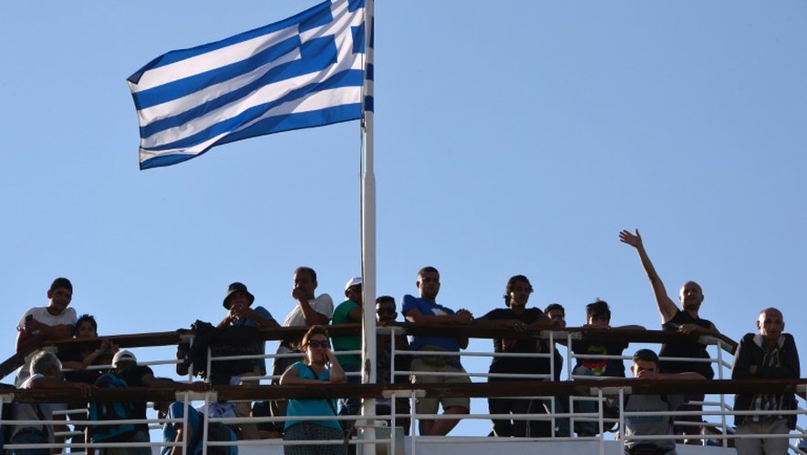 Des réfugiés syriens sur le ferry affrété par le gouvernement grec, le 20 août 2015 à son arrivée au port d'Athènes