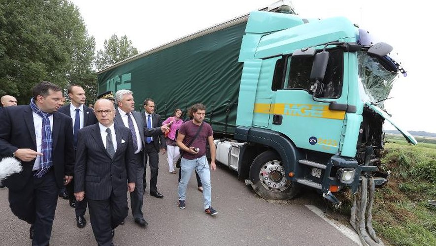 Le ministre de l'Intérieur Bernard Cazeneuve (3e à gauche) et le ministre des Transports Frédéric Cuvillier (4e à gauche) devant l'épave du poids-lourds après sa collision avec un minibus, près de Troyes le 22 juillet 2014