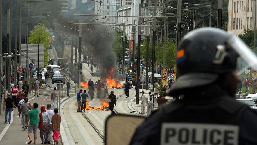 Un policier près de barricades en feu à Sarcelles le 20 juillet 2014