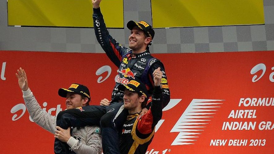 L'Allemand Sebastian Vettel (Red Bull), soulevé sur les épaules du Français Romain Grosjean (Lotus)(à droite) et de l'Allemand Nico Rosberg (Mercedes)(à gauche) après avoir remporté le Grand Prix d'Inde et son quatrième titre d'aff