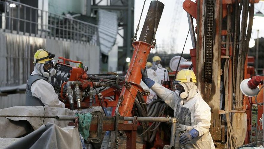 Des ouvriers préparent des tuyaux pour la construction d'un "mur de glace" censé réduire la quantité d’eau contaminée s’échappant dans l’océan, le 9 juillet 2014 à la centrale nucléaire de Fukushima, au Japon