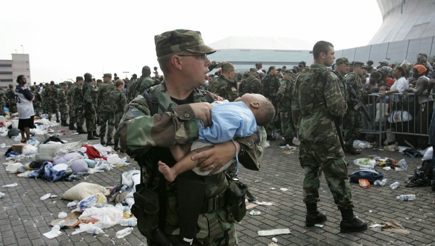 Un soldat tient un bébé alors que des gens attendent de quitter le Superdome de Nouvelle-Orléans, le 1er septembre 2005