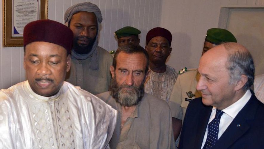 Le président du Niger Mahamadou Issoufou, les otages français libérés Thierry Dol et Daniel Larribe et le ministre français des Affaires étrangères Laurent Fabius, à l'aéroport de Niamey, le 29 octobre 2013