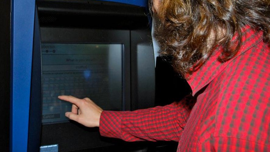 Une personne utilise la borne d'échange de bitcoin installée à Vancouver le 29 octobre 2013