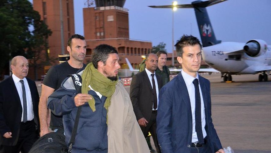 L'ex-otage Pierre Legrand (c) à son arrivée le 30 octobre 2013 à l'aéroport de Niamey. A gauche: Jean-Yves Le Drian