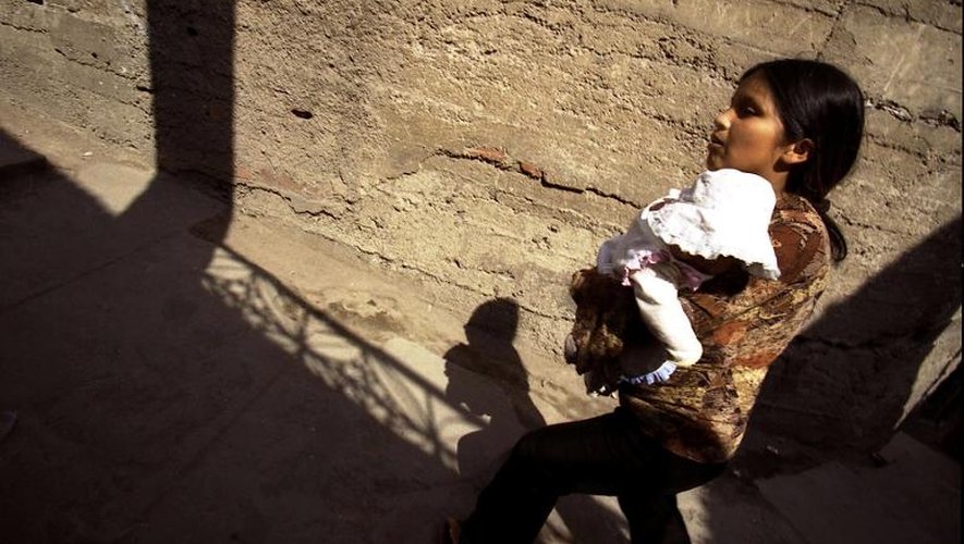 Une jeune Péruvienne de 14 ans avec sa fille, près de Lima, le 20 novembre 2003