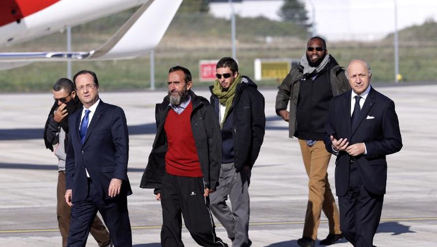 François Hollande et Laurent Fabius avec les 4 ex-otages, Marc Feret, Daniel Larribe, Pierre Legrand et Thierry Dol, le 30 octobre 2013 à l'aéroport militaire de Villacoublay