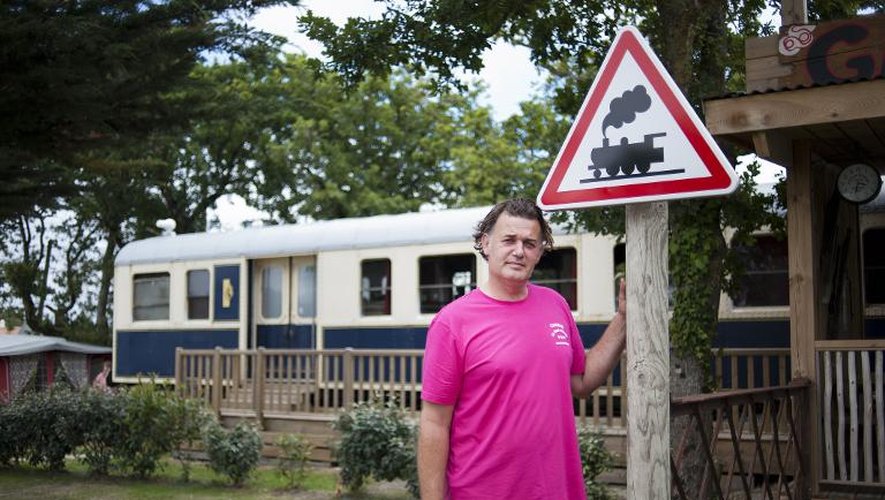 Guillaume Staub, le propriétaire du camping de Saint-Michel-Chef-Chef, pose devant un wagon de train le 15 juillet 2014