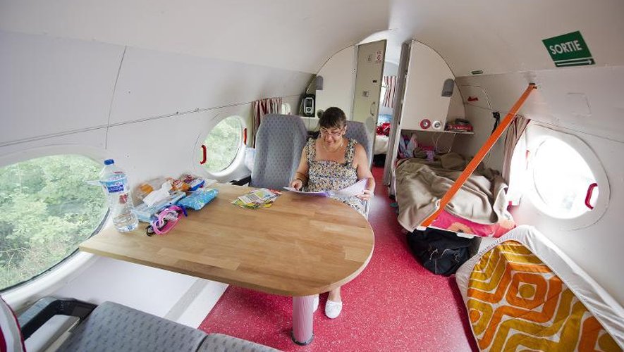 Une touriste assise dans une réplique d'avion au camping de Saint-Michel-Chef-Chef