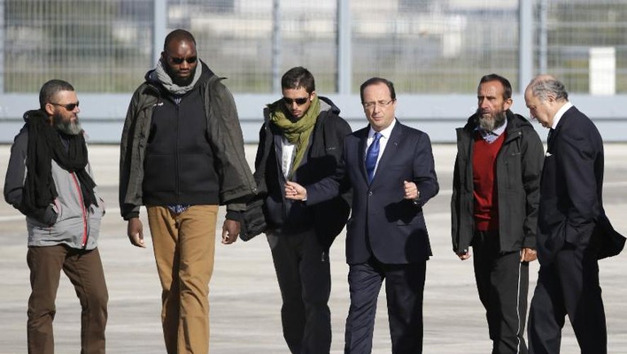 Les quatre otages (de gauche à droite) Marc Feret, Thierry Dol, Pierre Legrand et Daniel Larribe à leur arrivée le 30 octobre 2013 à Villacoublay, accompagnés du président de la République, François Hollande, et du ministre des Aff