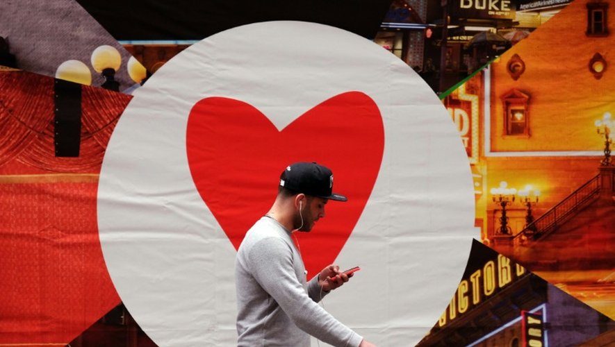 Un homme consulte son smartphone en marchant dans la rue, le 4 mars 2015 à New York