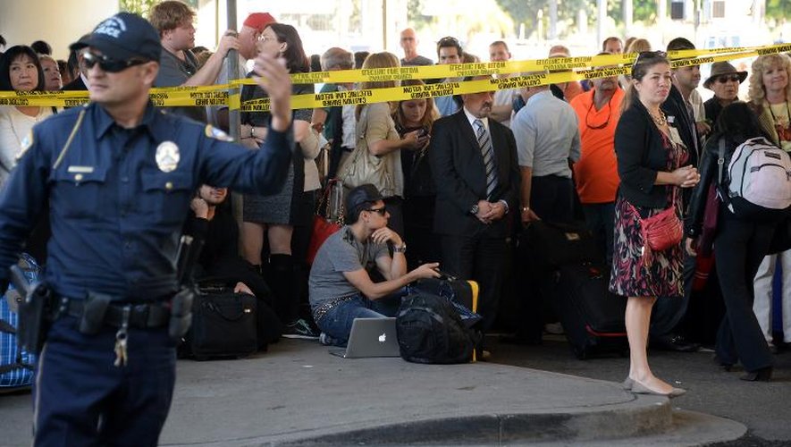 Des passagers attendent à l'extérieur de l'aéroport de Los Angeles après une fusillade, le 1er novembre 2013