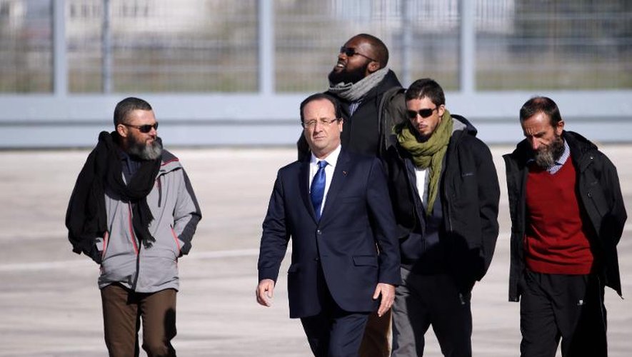 Le président François Hollande et les ex-otages Marc Feret, Thierry Dol, Pierre Legrand et Daniel Larribe, à leur arrivée à l'aéroport de Villacoublay, le 30 octobre 2013 près de Paris