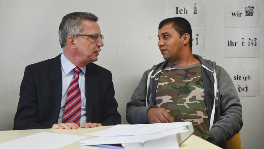Le ministre allemand des Affaires étrangères, Thomas de Maiziere, s'entretient avec un réfugié syrien dans le camp de transit de Friedland, dans le centre de l'Allemagne
