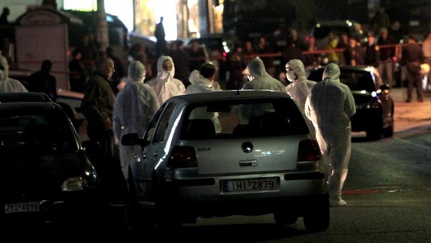 Des policiers du service antiterroriste examinent les lieux d'une fusillade qui a fait deux morts près d'un local du parti Aube Dorée, le 1er novembre 2013 à Athènes
