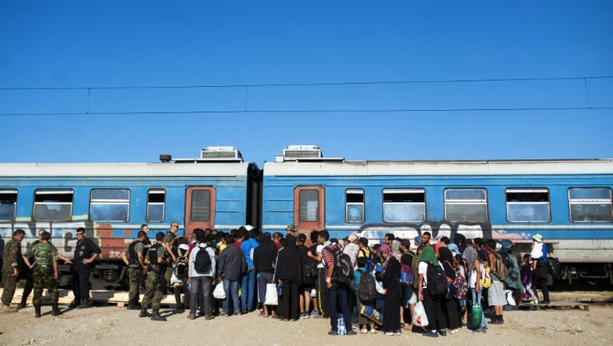 Des migrants attendent pour monter dans un train à destination de la Serbie, près de la ville de Gevgelija en Macédoine à la frontière avec la Grèce le 23 août 2015