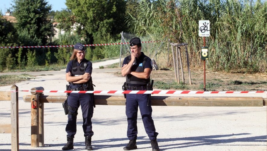 Deux policiers bloquent l'accès le 26 août 2015 du parc de Perpignan où une jeune fille a été trouvée égorgée