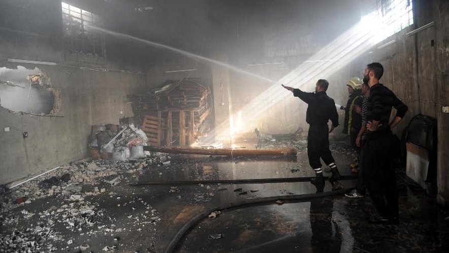 Photo fournie par l'agence de presse officielle syrienne Sana montrant une usine textile incendiée après la chute d'un obus de mortier, le 3 novembre 2013