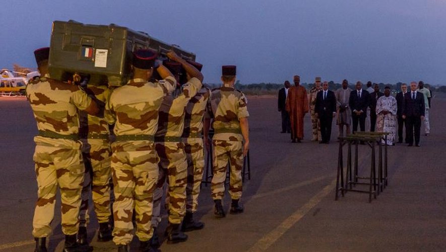 Des soldats transportent le cercueil de l'un des journalistes de RFI tués à Kidal, à l'aéroport de Bamako, le 3 novembre 2013