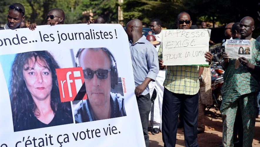 Des journalistes maliens tiennent les portraits des deux reporters français abattus dans le nord du Mali, le 4 novembre 2013 à Bamako