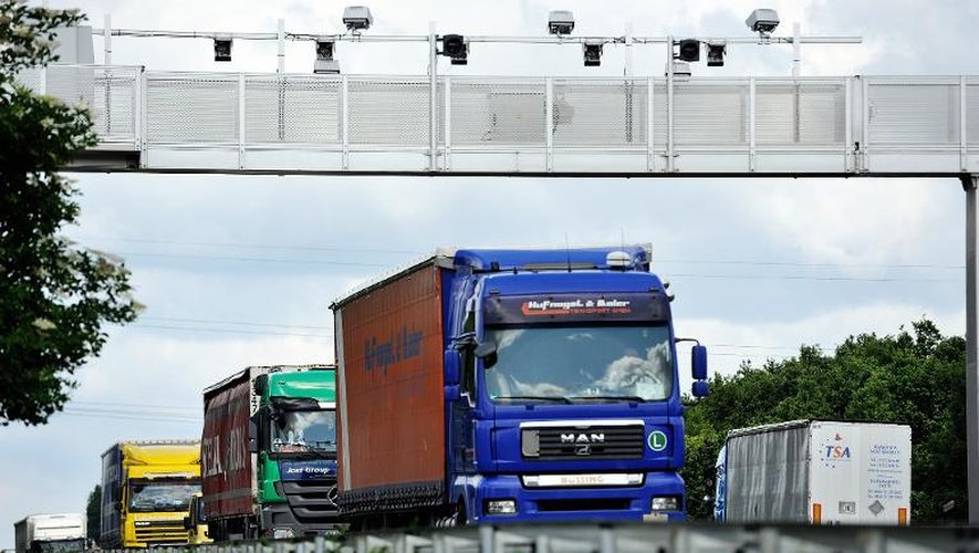 Des camions passent le 27 juin 2013, sur l'autoroute A25 près d'Armentières, dans le nord, sous un portique, censé vérifier si les véhicules ont bien payé l'écotaxe