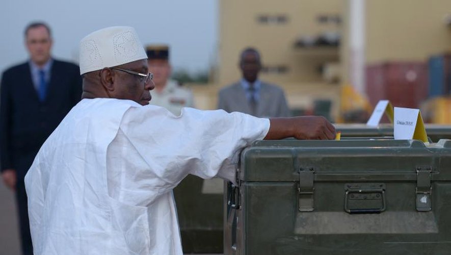 Le président malien Ibrahim Boubacar Keita décore,  à titre posthume les journalistes français tués à Kidal, le 4 novembre 2013 à l'aéroport de Bamako