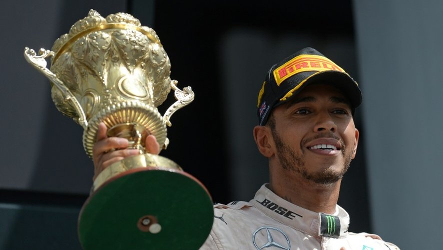 Le Britannique Lewis Hamilton (Mercedes), soulève le trophée après sa victoire au GP de Grande-Bretagne sur le circuit de Silverstone, le 10 juillet 2016