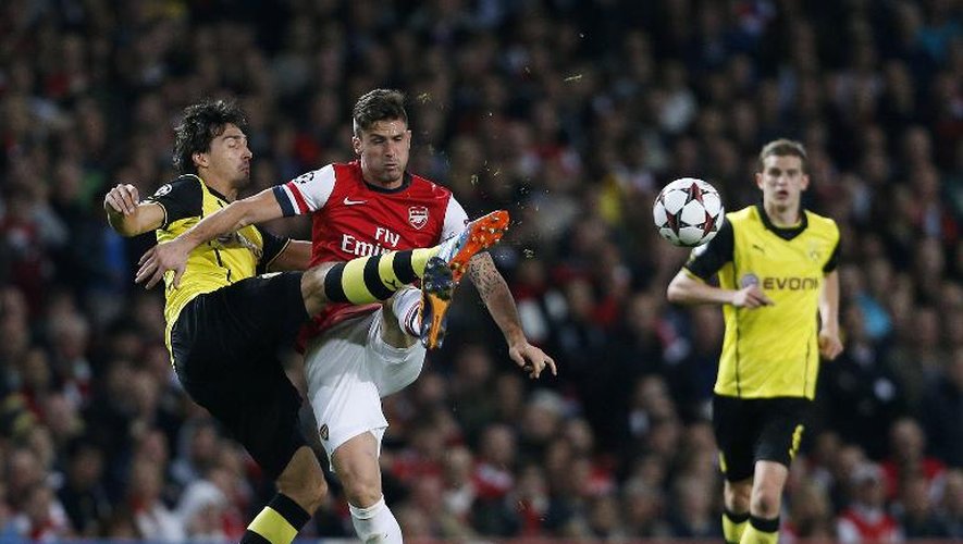 L'attaquant d'Arsenal Olivier Giroud (c) aux prises avec le défenseur de Dortmund  Mats Hummels (g), lors du match aller à l'Emirates Stadium, à Londres, le 22 octobre 2013