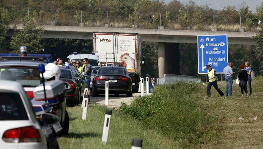 Des policiers autour du camion abandonné sur la bande d'arrêt d'urgence d'une autoroute dans lequel des corps en décomposition ont été découverts le 27 août 2015 près de Neusiedl am See en Autriche