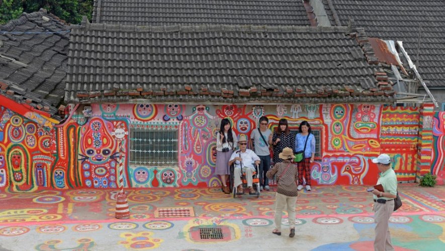 Des touristes se font prendre en photo le 19 août 2015 dans le "village Arc-en-ciel" de Taichung, à Taïwan