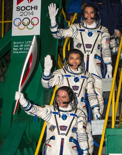Les spationautes russe Mikhaïl Tiourine qui tient la flamme olympique, japonais Koichi Wakata et américain Rick Mastracchio avant de décoller de Baïkonour à bord d'un vaisseau Soyouz, le 7 novembre 2013