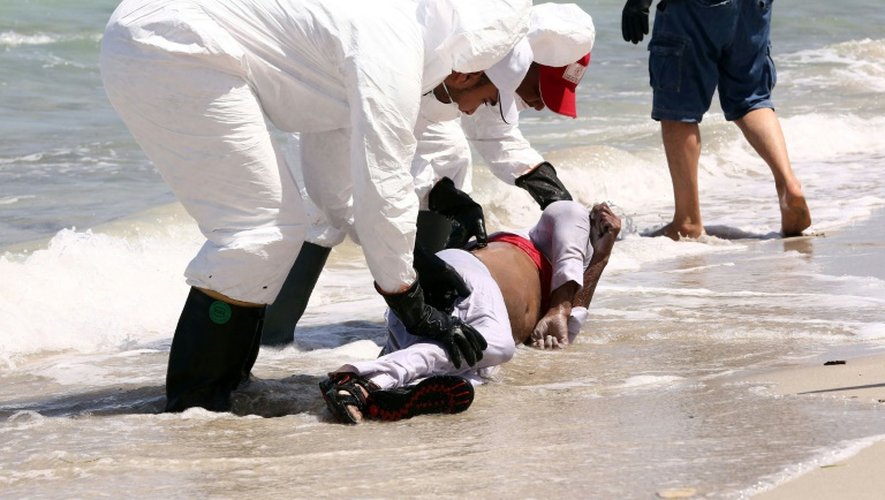 Des membres du Croissant rouge libyen récupèrent le corps d'un migrant échoué sur une plage près de Zuwara, à 160 km à l'ouest de Tripoli, le 28 août 2015