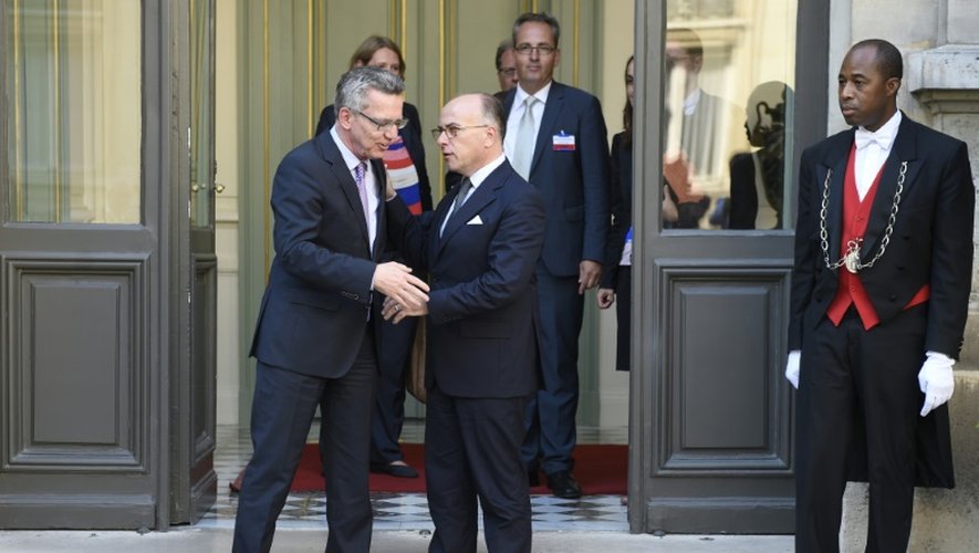 Le ministre de l'Intérieur Bernard Cazeneuve serre la main de son homologue allemand Thomas de Maizière le 29 août 2015 à Paris