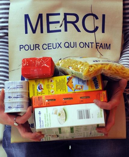 Une bénévole de la banque alimentaire du Nord collecte des denrées auprès de clients dans un supermarché de Lille le 26 Novembre 2010