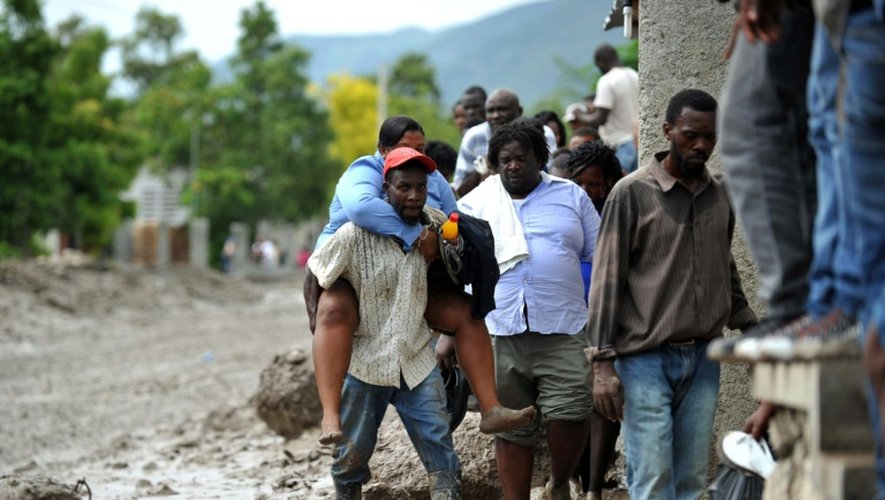 Des Haïtiens dans la boue après le passage de la tempête tropivale le 29 août 2015 à Montrouis