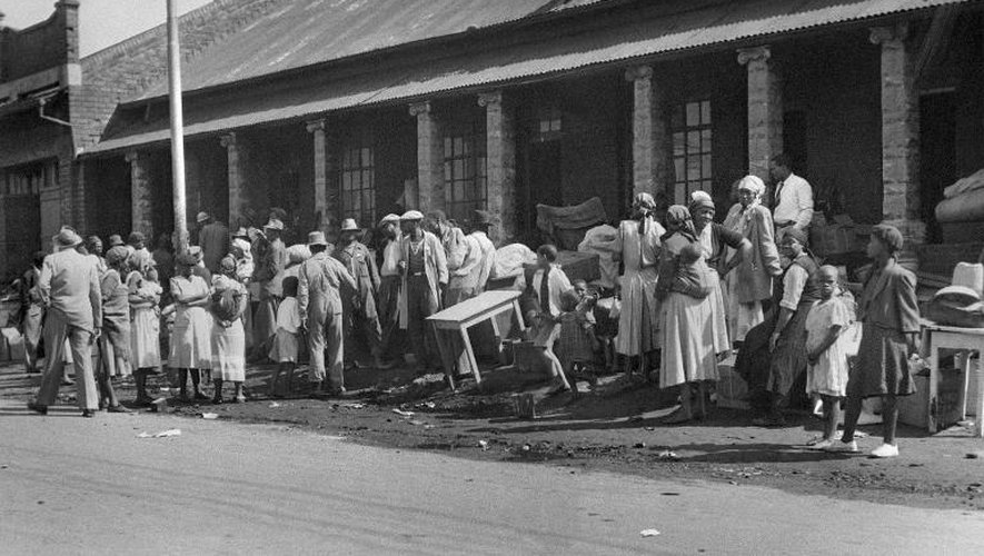 Des habitants de Sophiatown rassemblent leurs biens, le 21 février 1955, avant d'être évacués vers Meadowlands, aujourd'hui un quartier de Soweto