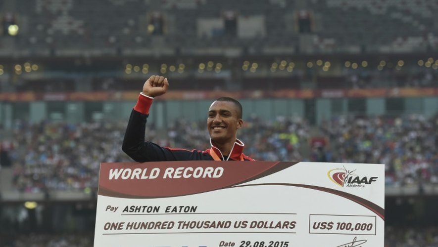 L'Américain Ashton Eaton et son chèque de 100.000 dollars pour son record du monde du décathlon lors des Championnats du monde de Pékin le 30 août 2015
