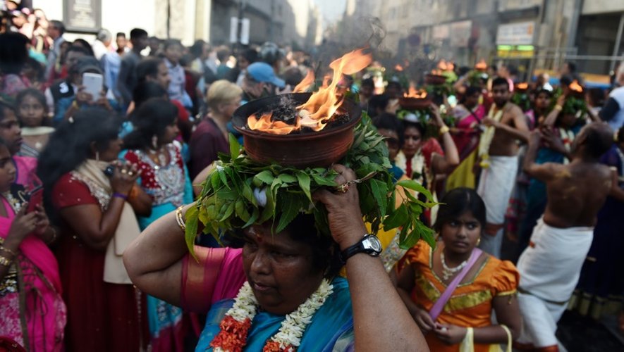 Des fidèles hindoues portent des pots contenant du camphre enflammé, en l'honneur du dieu Ganesh, le 30 août 2015 à Paris