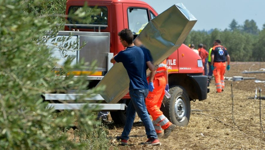 Un secouriste transporte un cercueil, le 12 juillet 2016 près de Corato en Italie
